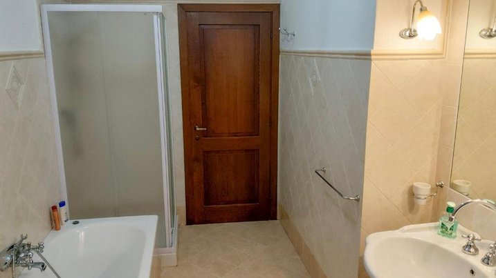 Bagno con doccia, vasca e lavabo
