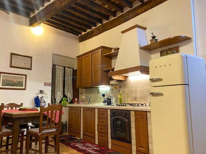 Cucina a vista sotto le travi di legno, con frigorifero Smeg