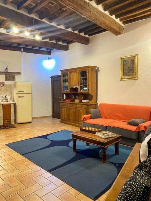 Soggiorno con credenza in legno e divano arancione
