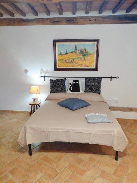 Letto matrimoniale con quadro di paesaggio toscano