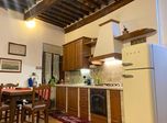 Cucina a vista sotto le travi di legno, con frigorifero Smeg