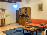 Soggiorno con credenza in legno e divano arancione