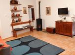 Il soggiorno con divano letto, tappeto blu e stufa