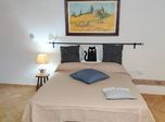 Letto matrimoniale con quadro di paesaggio toscano
